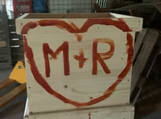 M + R painted in a red heart on a beehive